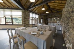 a dining room with tables and chairs and windows at Lar de Donas in Meira