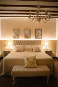a bedroom with a large bed with a chandelier at La casa del huerto in Caravaca de la Cruz