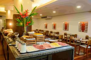a buffet line with food on display in a restaurant at Hotel Luzeiros Fortaleza in Fortaleza