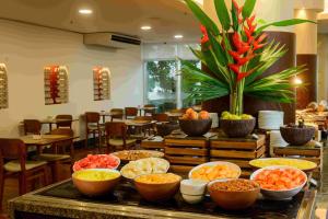 a buffet with bowls of food on a table at Hotel Luzeiros Fortaleza in Fortaleza