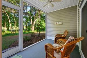 un porche grillagé avec deux chaises en osier et un ventilateur de plafond dans l'établissement 63A Fairway View Escape condo by Peace Vacations, à Pawleys Island