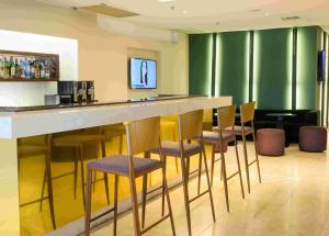 a bar in a room with chairs around it at Hotel Luzeiros Fortaleza in Fortaleza