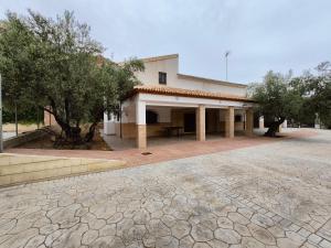 - un bâtiment avec une terrasse et des arbres devant dans l'établissement Casa rural Huertas del Castillo, à Benamejí