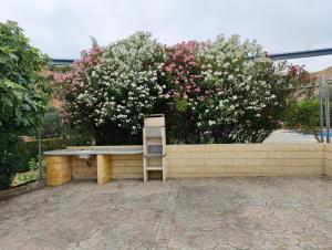 eine Bank, die vor einer Wand mit Blumen sitzt in der Unterkunft Casa rural Huertas del Castillo in Benamejí