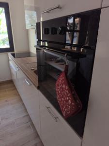 a kitchen with a black oven with a red basket on it at Seaside PERLA Apartment in Martinšćica +35 photos