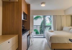 a hotel room with a bed and a balcony at 360 Ascent Paulista in Sao Paulo