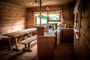 a kitchen with a bench and a table in a cabin at Purvmaļi in Daugavpils
