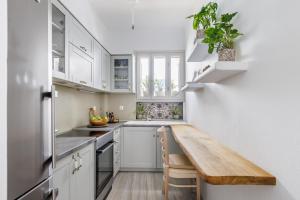a kitchen with white cabinets and a wooden table at Amaranthos Village Home in Skopelos Town +15 photos