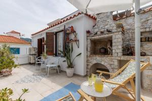 a patio with a stone fireplace and a table and chairs at Amaranthos Village Home in Skopelos Town
