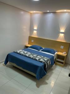 a bedroom with a bed with a blue comforter at Hotel Flert - Tatuapé in São Paulo