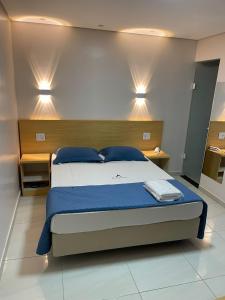 a bedroom with a bed and two lights on the wall at Hotel Flert - Tatuapé in São Paulo