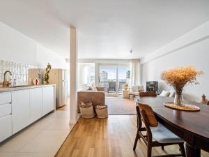 a kitchen and living room with a wooden table and a dining room at Maison Beaufort - uniek zicht op de jachthaven in Ostend