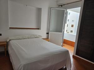 una camera da letto con un letto bianco e una grande finestra di Résidence Sable et Mer -Family ONLY- a Martil
