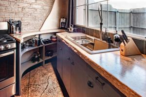 サンタフェにあるHeart of Vibrant Railyard-Downtown Loft with Radiant Heat and Deep Luxurious Soaking Tubのシンクとコンロのあるキッチン