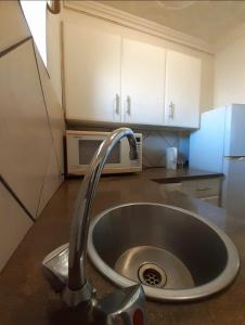 弗里尼欣Contractor Stay Vereeniging Guesthouse的厨房内的厨房水槽配有水龙头