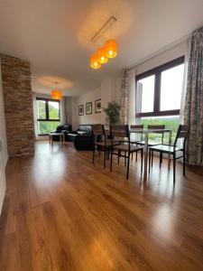 a living room with a table and chairs and a couch at APARTAMENTOS RioMonte 2 - DeLuxe in Boltaña +10 photos