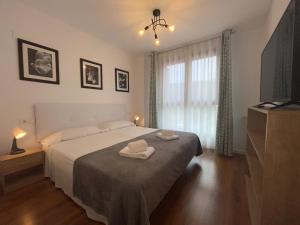 a bedroom with a bed with two towels on it at APARTAMENTOS RioMonte 2 - DeLuxe in Boltaña
