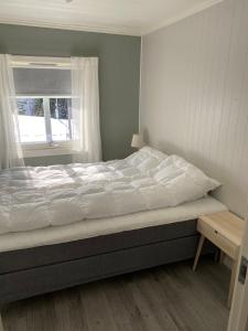 a bed in a bedroom with a window at Mørkveden feriehus, Lofoten in Ramberg