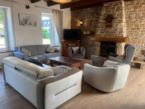- un salon avec des canapés et une cheminée en pierre dans l'établissement Ti Ar Familhou classée 3 étoiles, à Paimpol