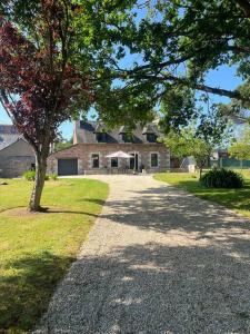 une route en gravier devant une maison avec un arbre dans l'établissement Ti Ar Familhou classée 3 étoiles, à Paimpol