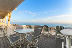 una terraza con sillas y mesas y el océano en Southbay by the Gulf 127 by Newman-Dailey, en Destin