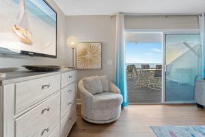 Una sala de estar con una cómoda y una silla y un balcón. en Southbay by the Gulf 127 by Newman-Dailey, en Destin