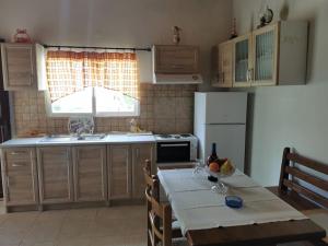 a kitchen with a table and a sink and a stove at Harmony beach house in Roda +12 photos