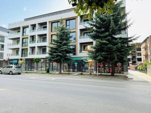 a car parked in front of a building with two trees at Shtastliveca Guest Apartment in Velingrad