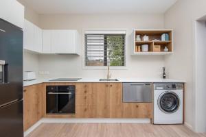 a kitchen with a sink and a washing machine at George Little Stylish, Peaceful & Convenient in Dunedin +6 photos