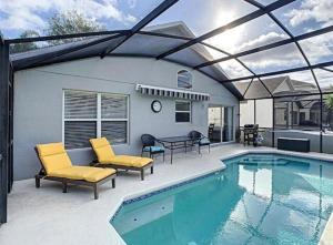 a patio with a pool and chairs and a table and a tablektop at Updated Private Pool Villa - Southern Dunes in Haines City