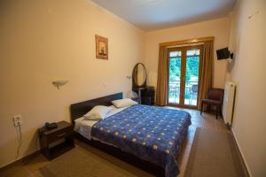 ein Schlafzimmer mit einem großen Bett und einem Fenster in der Unterkunft Hotel Tzoumerka in Pramanta