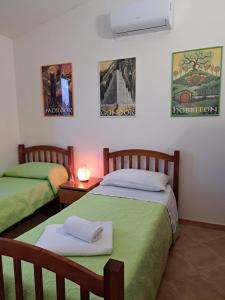 Un dormitorio con dos camas con sábanas verdes. en Isola's Apartments, en Pula