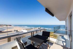 balcón con mesa y sillas y la playa en Apartamento Foz Arelho, en Foz do Arelho