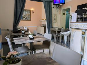 a restaurant with tables and chairs and a fireplace at Hotel Soggiorno Athena in Pisa