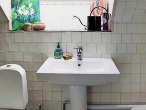 a bathroom with a white sink and a toilet at 4 star holiday home in Frillesås in Frillesås