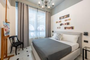a bedroom with a bed and a chair and a window at Giada Home Luxury in Genova City Centre in Genova