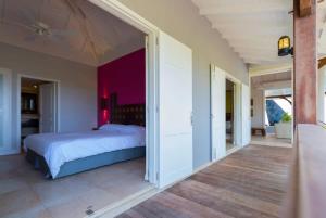 a bedroom with a large bed and a hallway at Tropical Breeze Villa in Domaine du Levant in Petit Cul de Sac