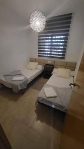 two beds in a room with a window and a chandelier at Apartamento Torre la Sal in Cabanes