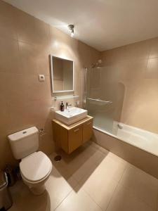 a bathroom with a toilet and a sink and a tub at Pedro’s Apartment in Sucina