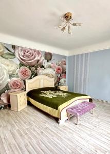 a bedroom with a bed with a mural of roses at fantasy park in Ventspils
