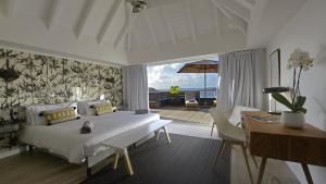 Petit Cul de SacにあるOcean Deluxe Villa in Petit Cul de Sacのベッドとテーブルと机のある寝室 +92枚の写真
