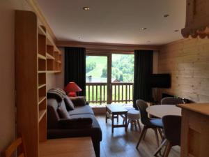 salon z kanapą i stołem w obiekcie Résidence Le Vallon - Appartement 2 pièces pour 4-5 personnes situé à Méribel centre proche des commerces et des pistes de ski MAE-1766 w mieście Les Allues
