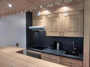 kuchnia z drewnianymi szafkami i zlewem w obiekcie Résidence Le Vallon - Appartement 2 pièces pour 4-5 personnes situé à Méribel centre proche des commerces et des pistes de ski MAE-1766 w mieście Les Allues +5 zdjęć