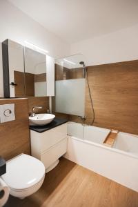 a bathroom with a toilet and a sink and a tub at Sternenblick Lodge, im Harz, mit Schwimmbad und Sauna in Braunlage