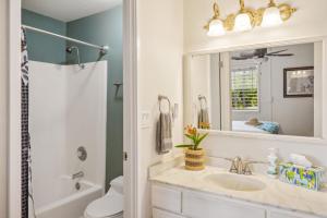 a bathroom with a sink and a mirror at Poipu Palms 302 in Koloa +23 photos
