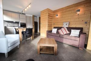 salon z kanapą i stołem w obiekcie Résidence Le Mont Blanc - 3 Pièces pour 6 Personnes 024 w Aime La Plagne