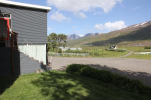 a house with a driveway next to a road with mountains at Draflastadir Guesthouse in Draflastaðir +28 photos