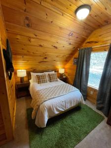 a bedroom with a bed in a wooden cabin at Cozy Cabin in Red River Gorge in Rogers