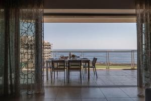 a dining room with a table and a view of the ocean at 602 Sliema 3bed Seafront With Pool By Homely in Sliema