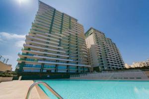 a large building with a swimming pool in front of it at 602 Sliema 3Bed seafront with Pool by Homely in Sliema
